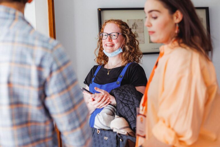 Two women and a nonbinary person chatting in a small circle.