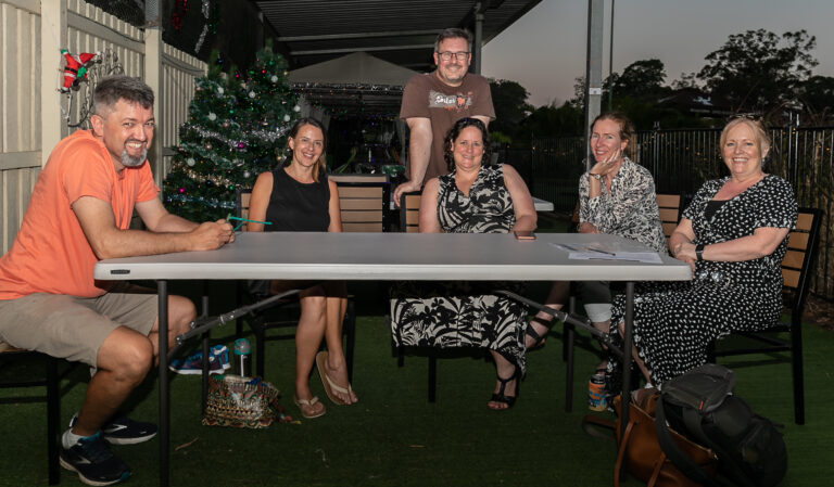 Six parents sitting around an outdoor folding table