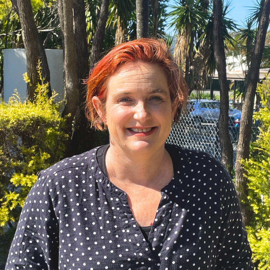 Danielle Flanagan, a short middle aged Irish woman with short, dyed red hair.