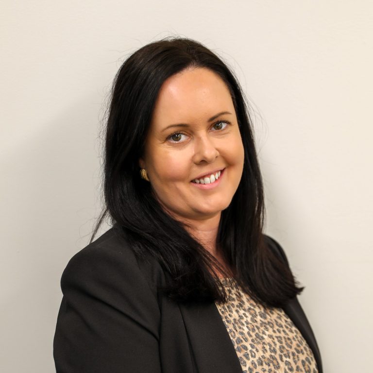 Photograph of Tamara, a white woman in her forties with shoulder length dark brown hair, a cheetah print blouse and a suit jacket.